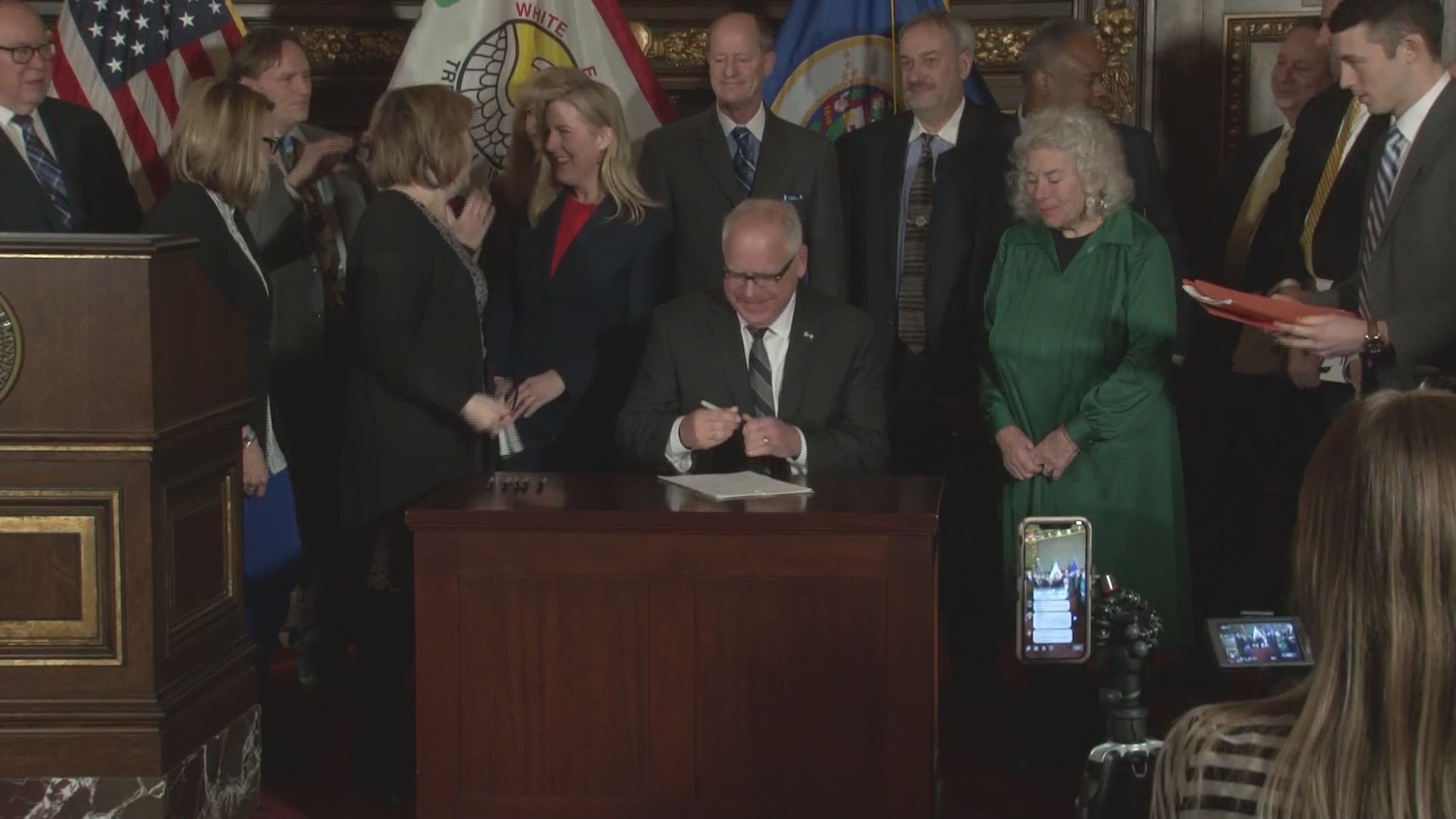 Gov. Tim Walz signed the first two bills of his administration Tuesday, saluting lawmakers from both parties for showing compromise in getting things done.