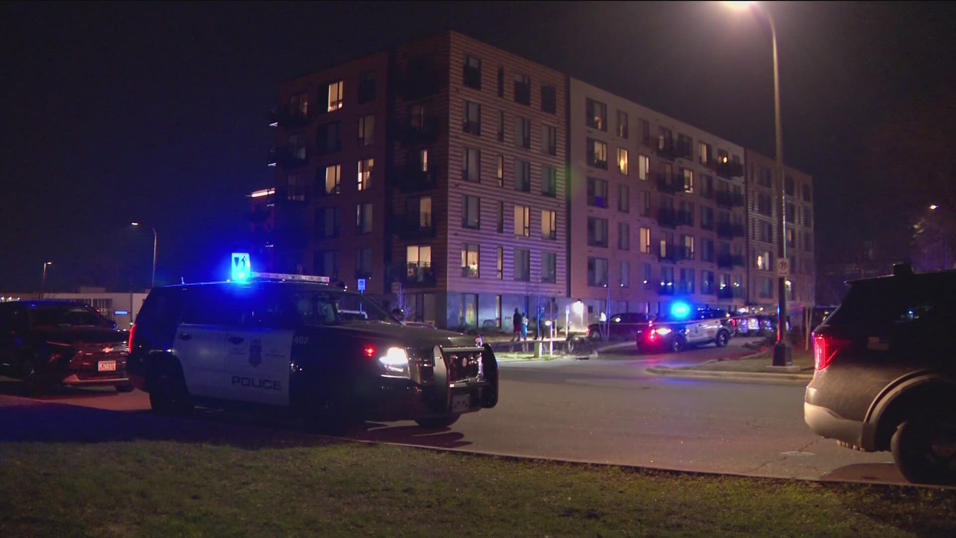 Police have arrested two people after a man was found shot in his car outside an apartment complex. 