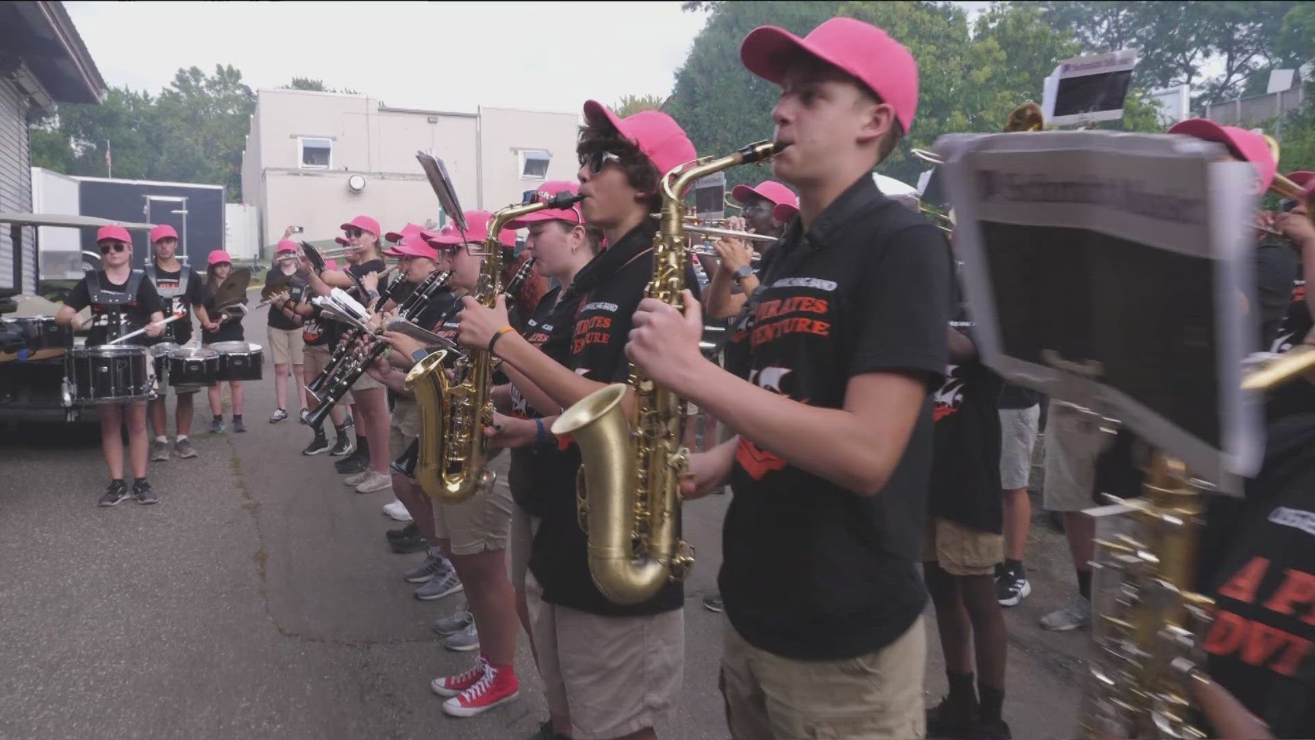 The Osseo High School marching band performs at the fair, donning red hats as they play "Barbie Girl."