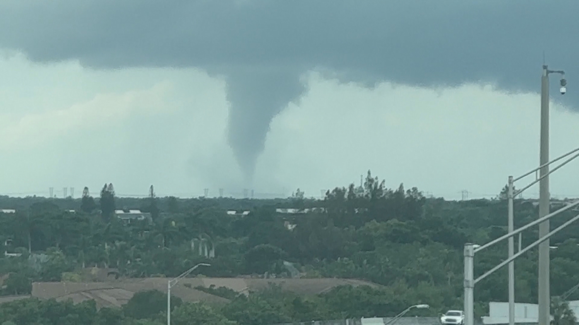 Local television crews capture the sights and sounds of large tornado on the ground near I-75, Alligator Alley, in Broward County Wednesday morning.