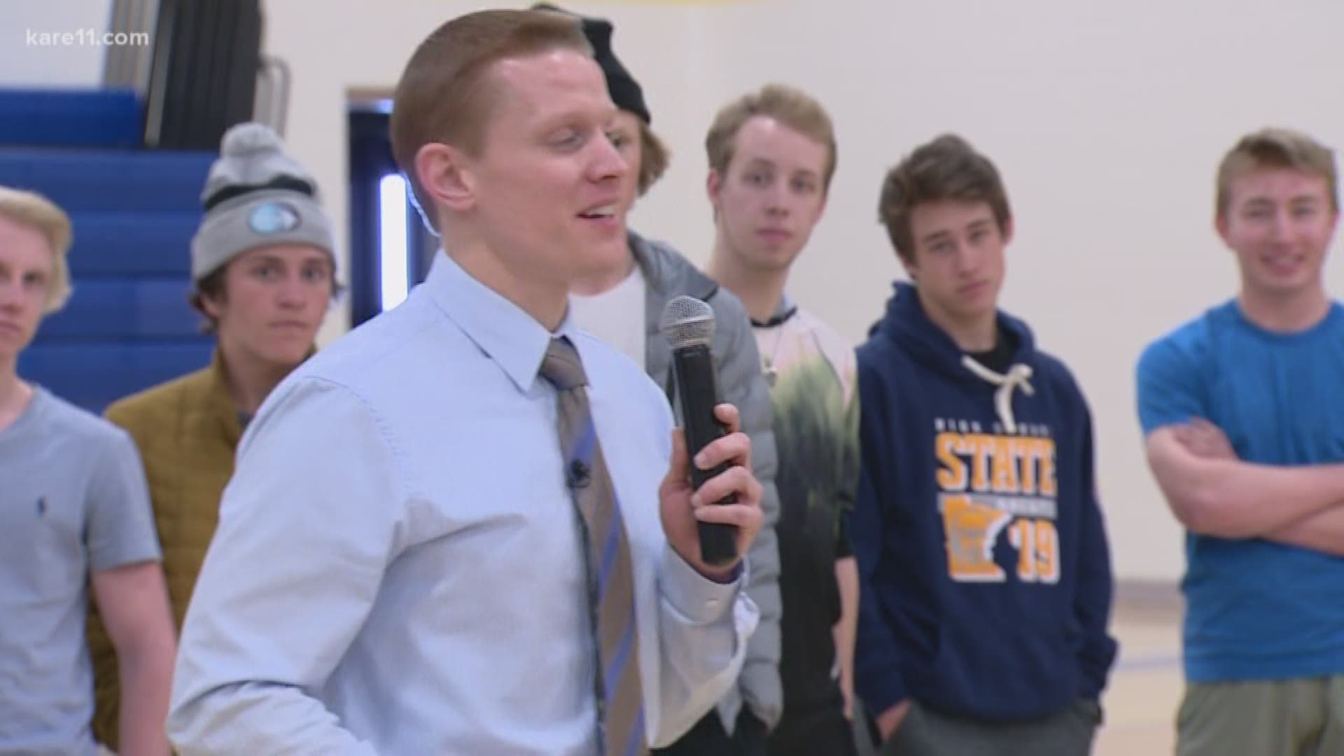 The members of the Minnesota high school hockey team that started their school year by shaving their heads arrived back at school to a standing ovation Monday.